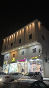 a building with cars parked in front of it at غرفة وصالة دخول ذكي in Al Fayşalīyah