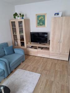 a living room with a blue couch and a television at Privat Veronika in Telč