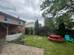 a backyard with a red picnic table and a blue chair at Luxurious Vacation in Welland