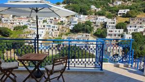 a table and chairs with an umbrella on a balcony at Comfort and unparalleled view in Kóronos