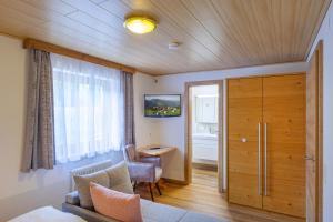 a living room with a door and a desk in a room at Bergbauernhof Familienparadies Oberhasenberghof in Taxenbach