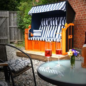 a table with two wine glasses on top of a bench at Romantisches SM Apartment Secret Passion in Fehmarn