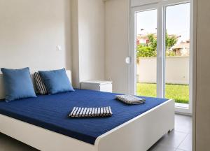 a bedroom with a bed with blue sheets and pillows at Lagonisi Apartment in Skála Nikíta