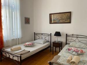 two twin beds in a room with a lamp at Mytilini Townhouse in Mytilene