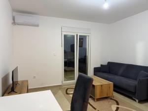 a living room with a blue couch and a table at Comfort Residence in Tuzi