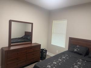 a bedroom with a mirror and a bed and a dresser at Matthews Blue House in Wilmer