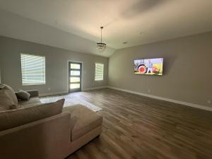 a living room with a couch and a flat screen tv at Matthews Blue House in Wilmer