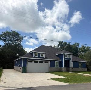 a blue house with a white garage at Matthews Blue House in Wilmer
