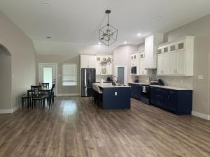 a large kitchen with white cabinets and blue appliances at Matthews Blue House in Wilmer