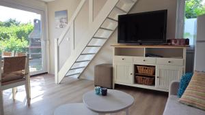 a living room with a flat screen tv on a cabinet at Vakantiehuis Topaz in Bruinisse