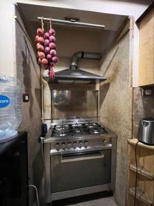 a stove in a kitchen with a bunch of onions at Kendaw home in Hihyā