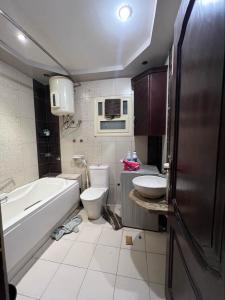 a bathroom with a tub and a toilet and a sink at Kendaw home in Hihyā