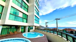 a balcony of a building with a hot tub at Studios Praia Grande - VISTA MAR in Arraial do Cabo