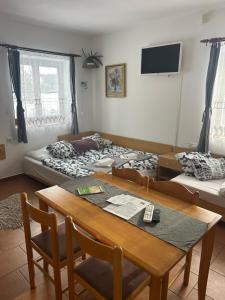 a room with two beds and a table and chairs at Slunečná Lada in Borová Lada
