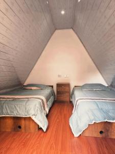 a room with two beds in a attic at EcoSereno Salkantay Huts Chaullay in Santa Teresa