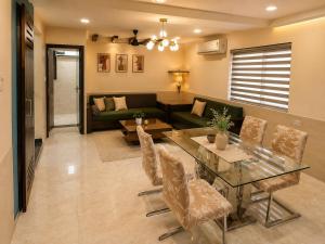 a living room with a glass table and a couch at Jacuzzi Room in a shared Villa with Swimming pool in Thane