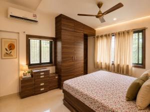 a bedroom with a bed and a ceiling fan at Jacuzzi Room in a shared Villa with Swimming pool in Thane