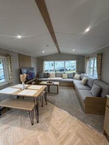 a living room with a couch and a table at The Elms Escape in Porthcawl