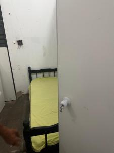 a bedroom with a bed with a yellow sheet at Dormitório in Uberlândia