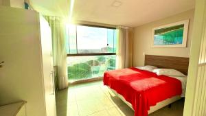 a bedroom with a red bed and a large window at Studios Praia Grande - VISTA MAR in Arraial do Cabo +23 photos
