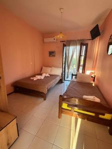 a room with two beds and a table in it at House Nativa in Mola Kalyva