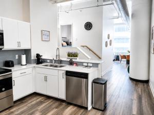 a kitchen with white cabinets and a stainless steel dishwasher at Urban Escape in Indianapolis