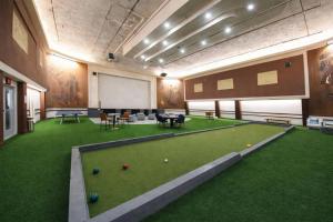 a large room with a pool table and balls on the grass at Urban Escape in Indianapolis
