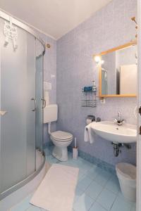 a bathroom with a toilet and a sink and a shower at K&D Home in Rab