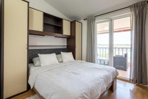 a bedroom with a large bed and a large window at K&D Home in Rab