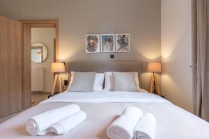 a bedroom with a white bed with towels on it at Art and Light in Argostoli