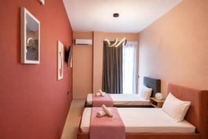 a hotel room with two beds and a window at Swan Paradise Tolo in Tolo