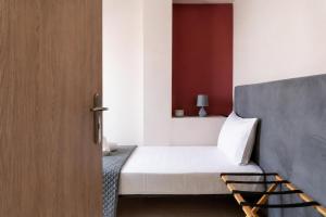 a bedroom with a bed and a wooden door at Swan Paradise Tolo in Tolo
