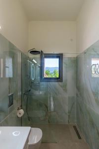 a bathroom with a shower and a toilet and a window at Art and Light in Argostoli +23 photos