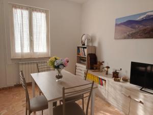 a dining room with a table with a vase of flowers on it at Casa Roncopiano in Cabanne