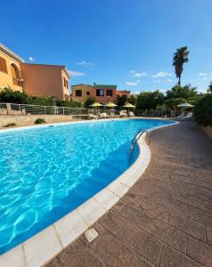a swimming pool with blue water in a resort at Leoncorno la Marina a Villasimius in Villasimius