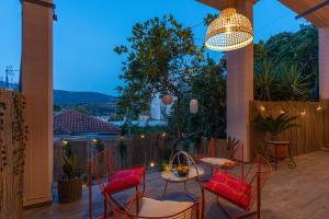 a patio with chairs and a table and a chandelier at Art and Light in Argostoli