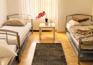 a bedroom with two beds and a table with a rug at Harzer Domschatz-Auszeit Monteure - Einzelbetten in Halberstadt