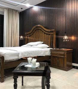 a bedroom with a large bed and a table at Hotel Plaza Park in Nathia Gali