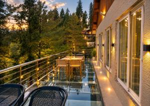 a balcony with a table and chairs on it at Hotel Plaza Park in Nathia Gali