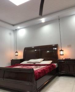 a bedroom with a large wooden bed with red sheets at Hotel Plaza Park in Nathia Gali