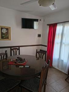 a dining room with a glass table and a red curtain at Duplex EyC in Colón