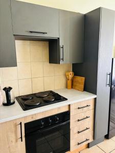 a kitchen with a stove top oven next to a refrigerator at Airport Urban Studio in Benoni