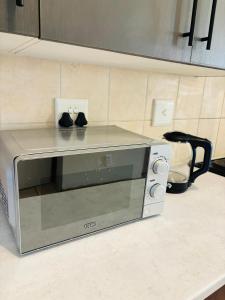 a microwave oven sitting on a counter in a kitchen at Airport Urban Studio in Benoni