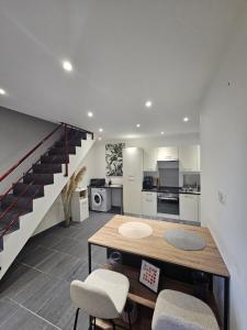 a kitchen with a table and chairs and a staircase at Ma p'tite maison in Fumay