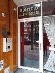 a glass door of a building with a sign on it at Monoambiente en pleno centro de Adrogué in Adrogué