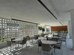 a dining room with tables and chairs and windows at Salinas Beach Resort in Salinópolis