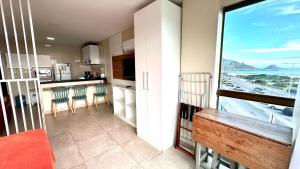 a kitchen with a view of the ocean from a balcony at Studios Praia Grande - VISTA MAR in Arraial do Cabo