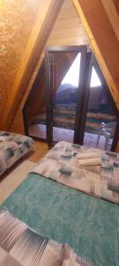 an attic room with two beds and a window at Hasan's Place Temnjaci in Plav +13 photos