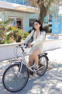 a woman riding a bike down the street at Hotel Milord in Cesenatico