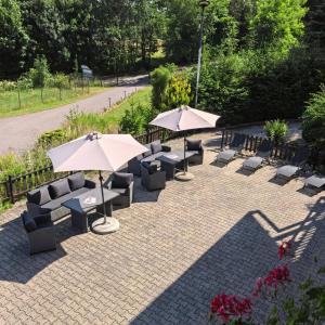 a patio with couches and umbrellas and chairs at Apartmán Centrum Pastvinská přehrada in Nekoř +4 photos